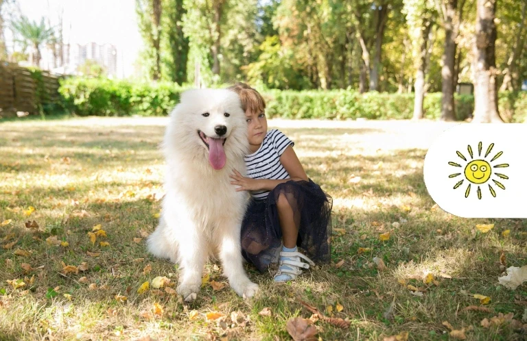 Dziewczynka siedząca z psem rasy Samoyed